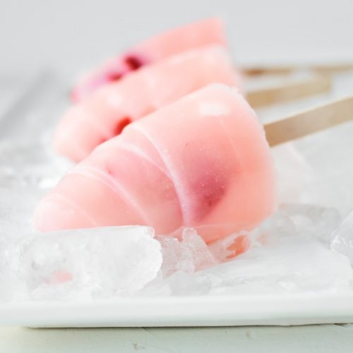 Homemade Strawberry Milk Popsicles on ice