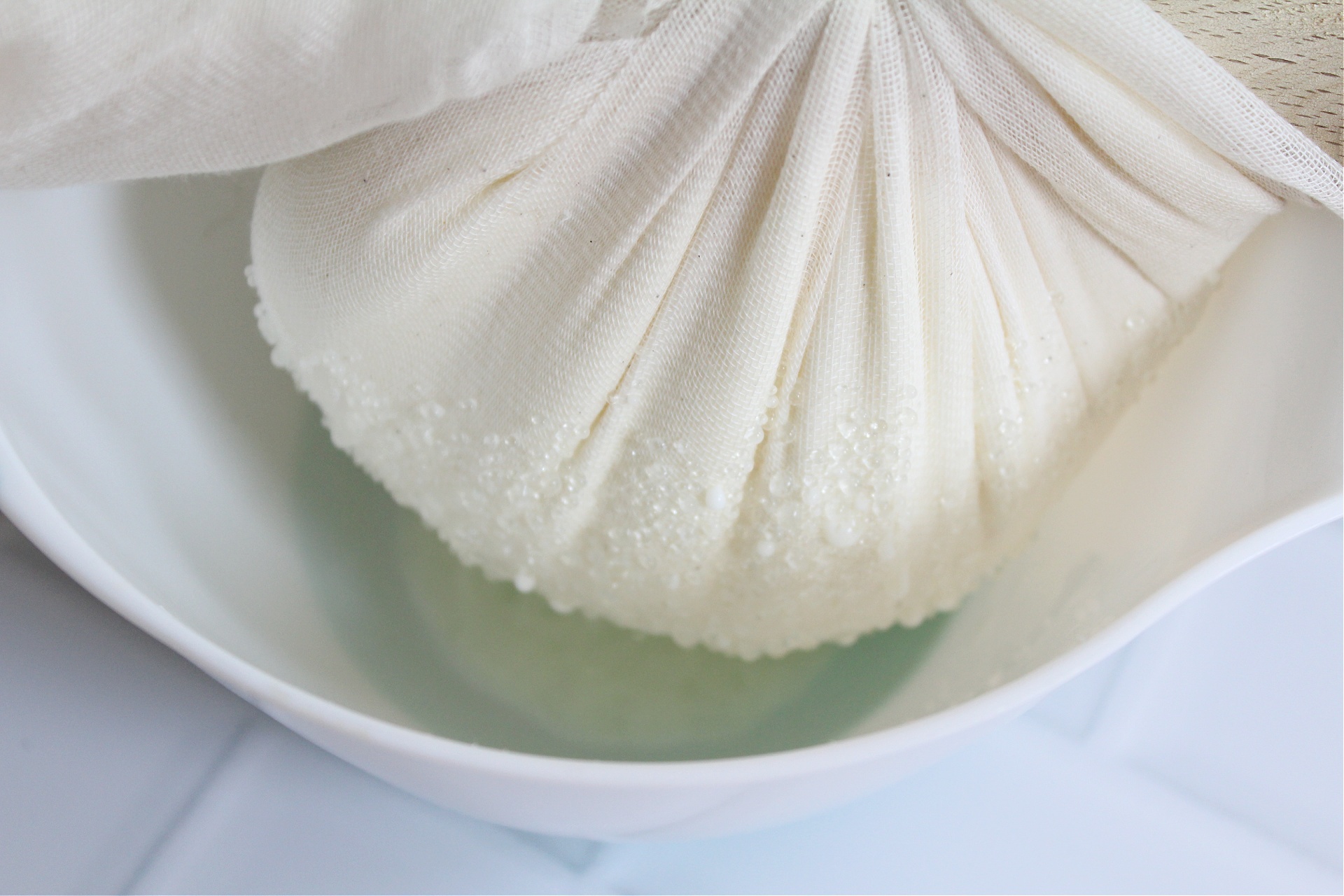 making labneh cheese with cheesecloth