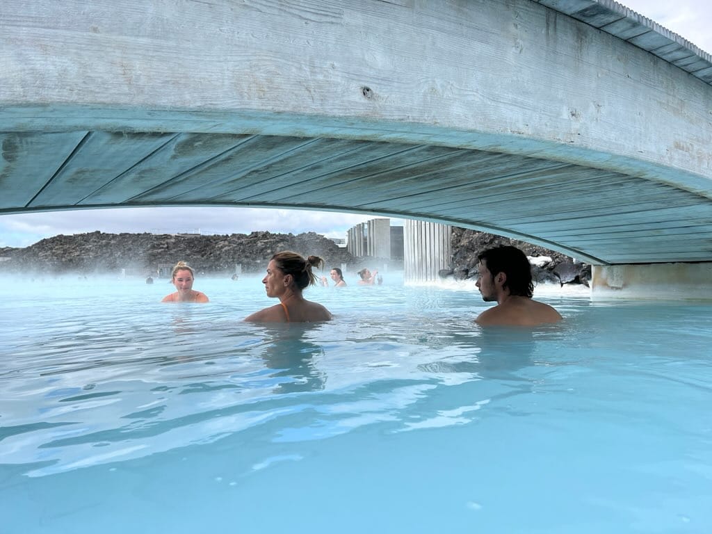 Visitors enjoying the milky blue waters of the Blue Lagoon geothermal spa in Iceland surrounded by black lava rock. Visitors enjoying the milky blue waters of the Blue Lagoon geothermal spa in Iceland surrounded by black lava rock.