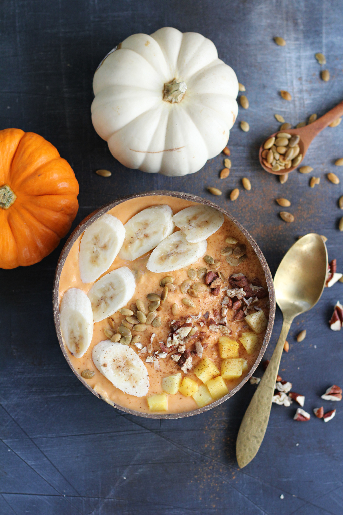 Vibrant mango and pumpkin smoothie bowl with watermelon, banana slices, and crunchy pecans