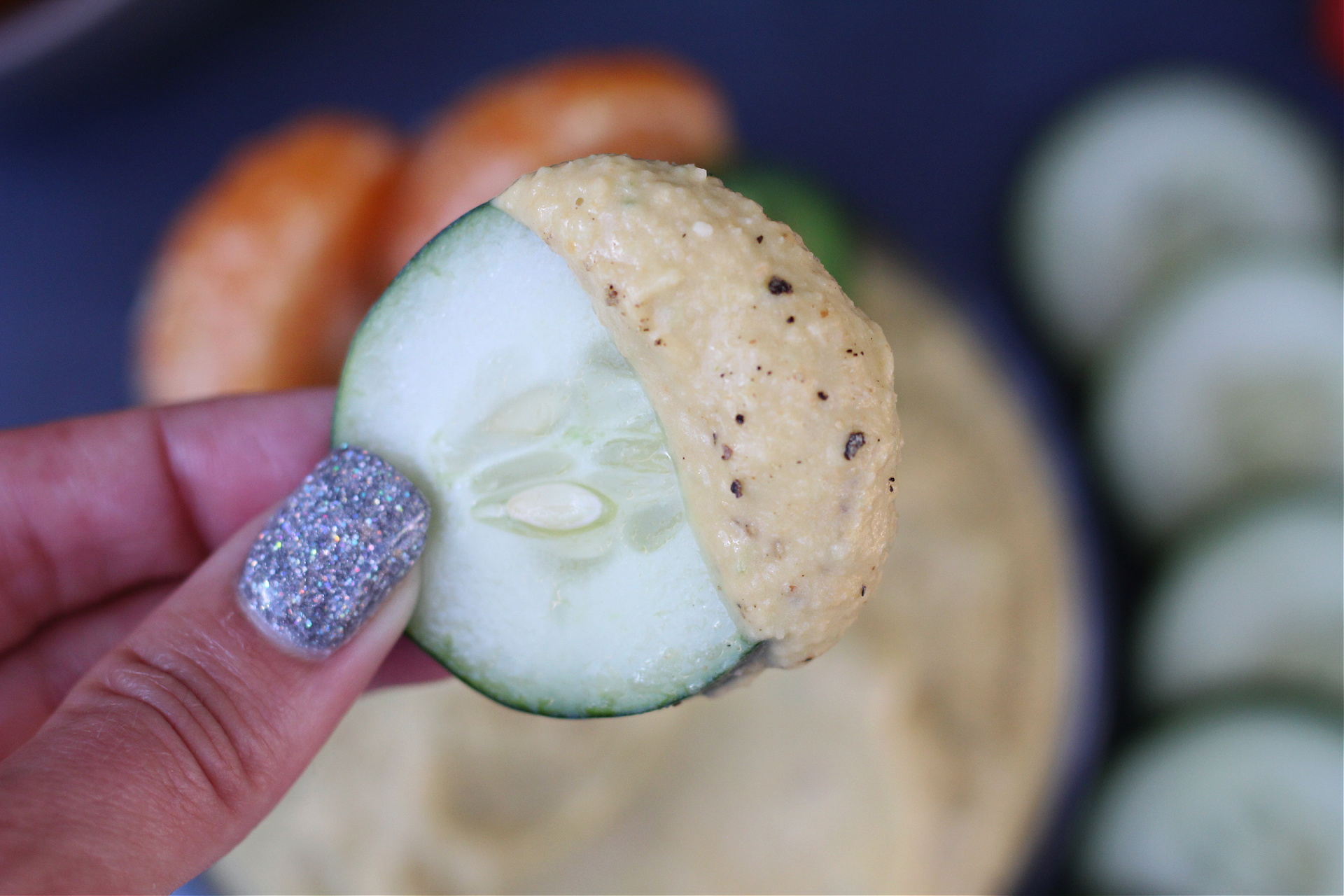 Close-up of creamy hummus on a cucumber slice. Close-up of creamy hummus on a cucumber slice.