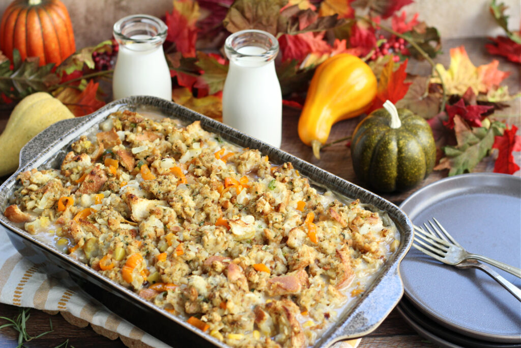 Baked Thanksgiving Leftover Casserole in a 9&times;13 pan, golden top and ready to serve with a glass of milk, ideal for using holiday leftovers.