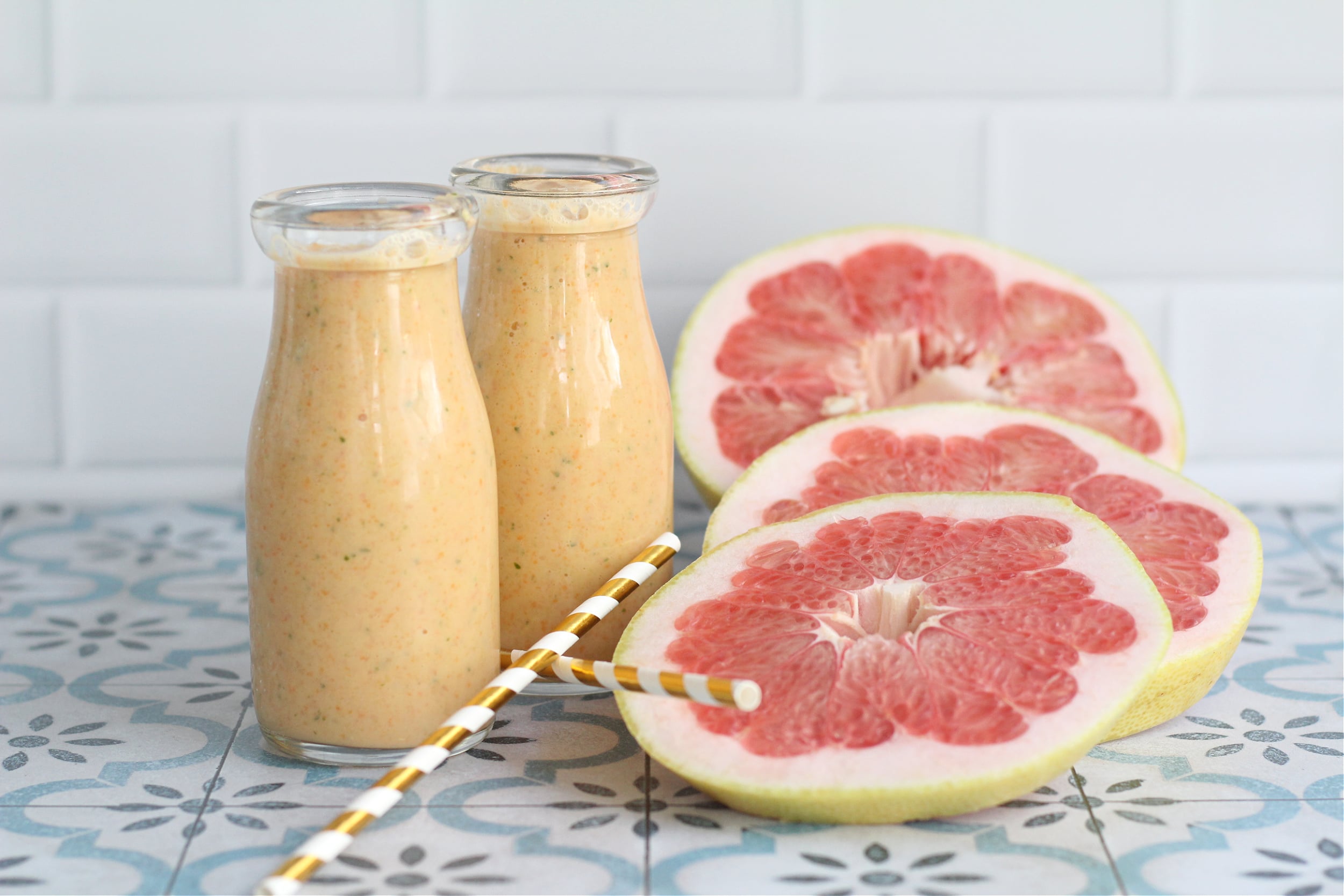 Two Glasses of Florida citrus smoothie with fresh pummelo slices on the side. Two Glasses of Florida citrus smoothie with fresh pummelo slices on the side.