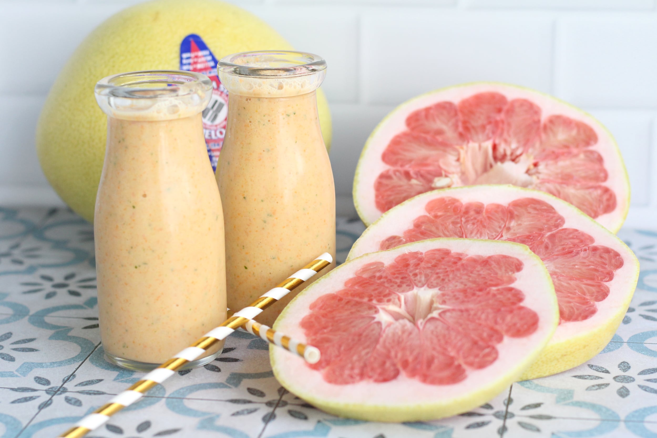 Citrus smoothie garnished with an pummelo slices and a whole pummelo in the background. Citrus smoothie garnished with an pummelo slices and a whole pummelo in the background.