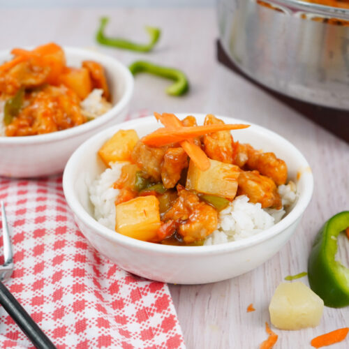 Easy sweet and sour chicken recipe with golden chicken, peppers, and pineapple on rice.