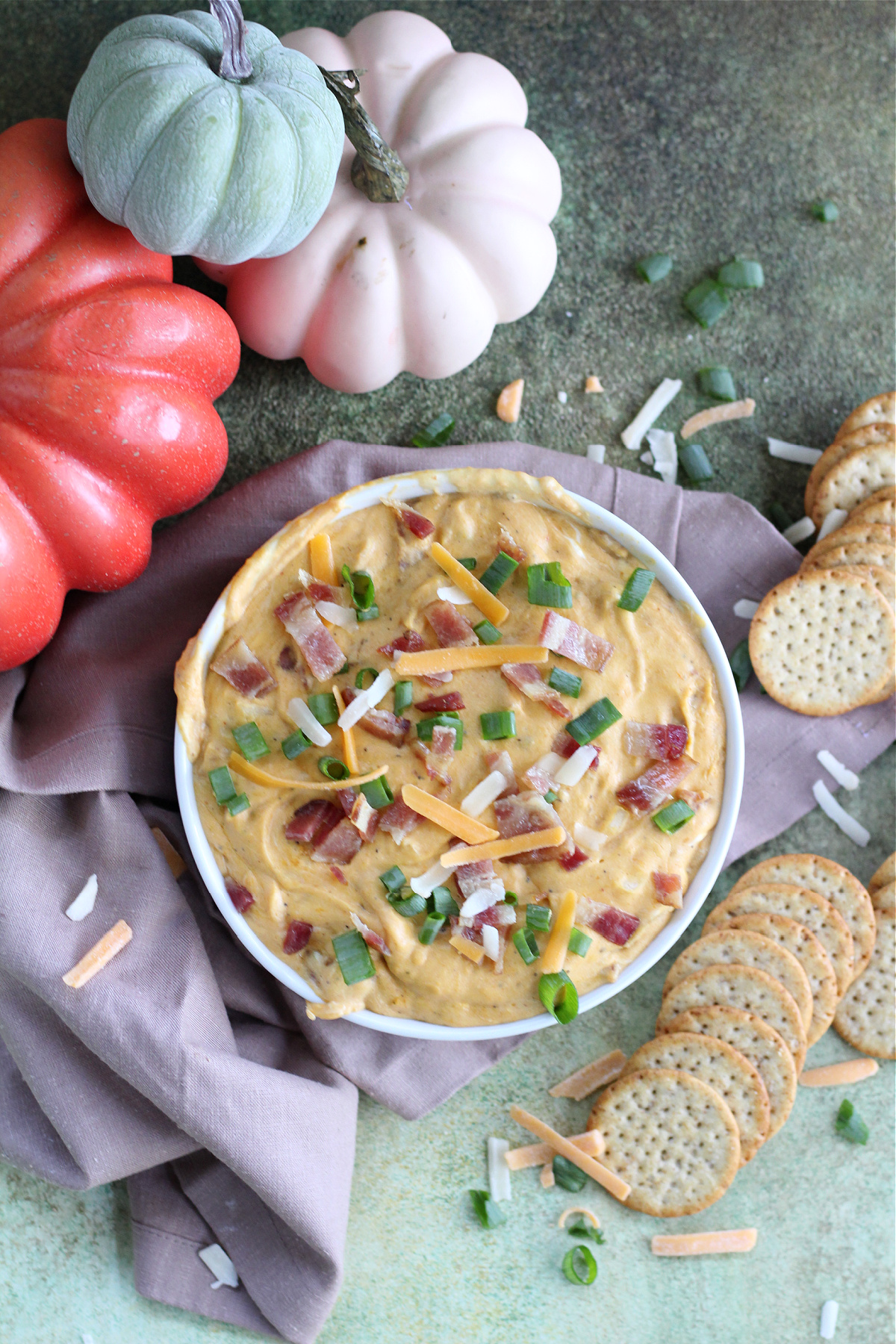 Golden bubbly pumpkin and bacon dip fresh from the oven with green onion and bacon garnish