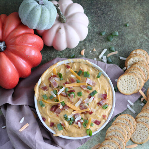Fall party appetizer spread featuring pumpkin and bacon dip, and rustic fall decor