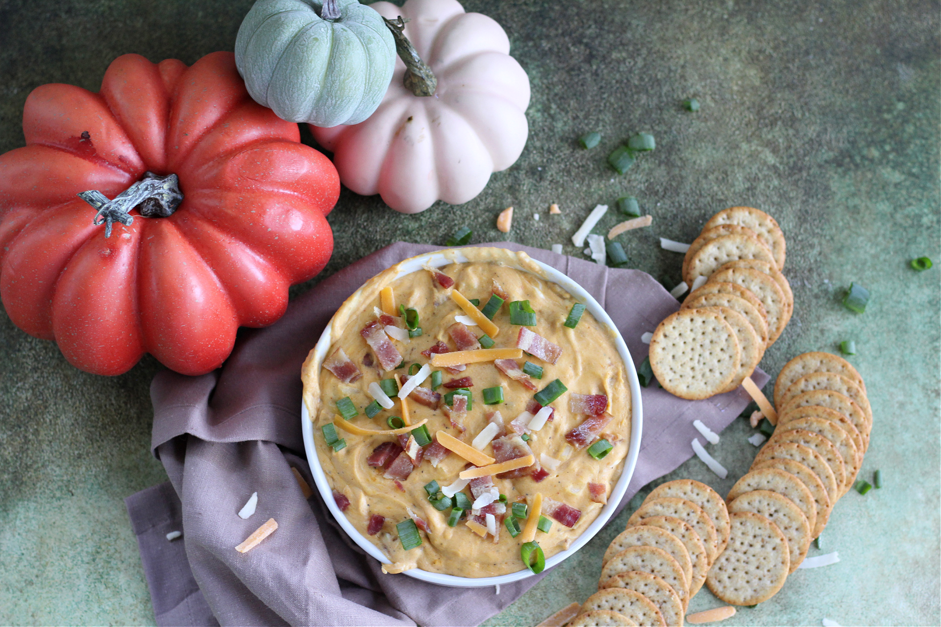 Fall party appetizer spread featuring pumpkin and bacon dip, and rustic fall decor
