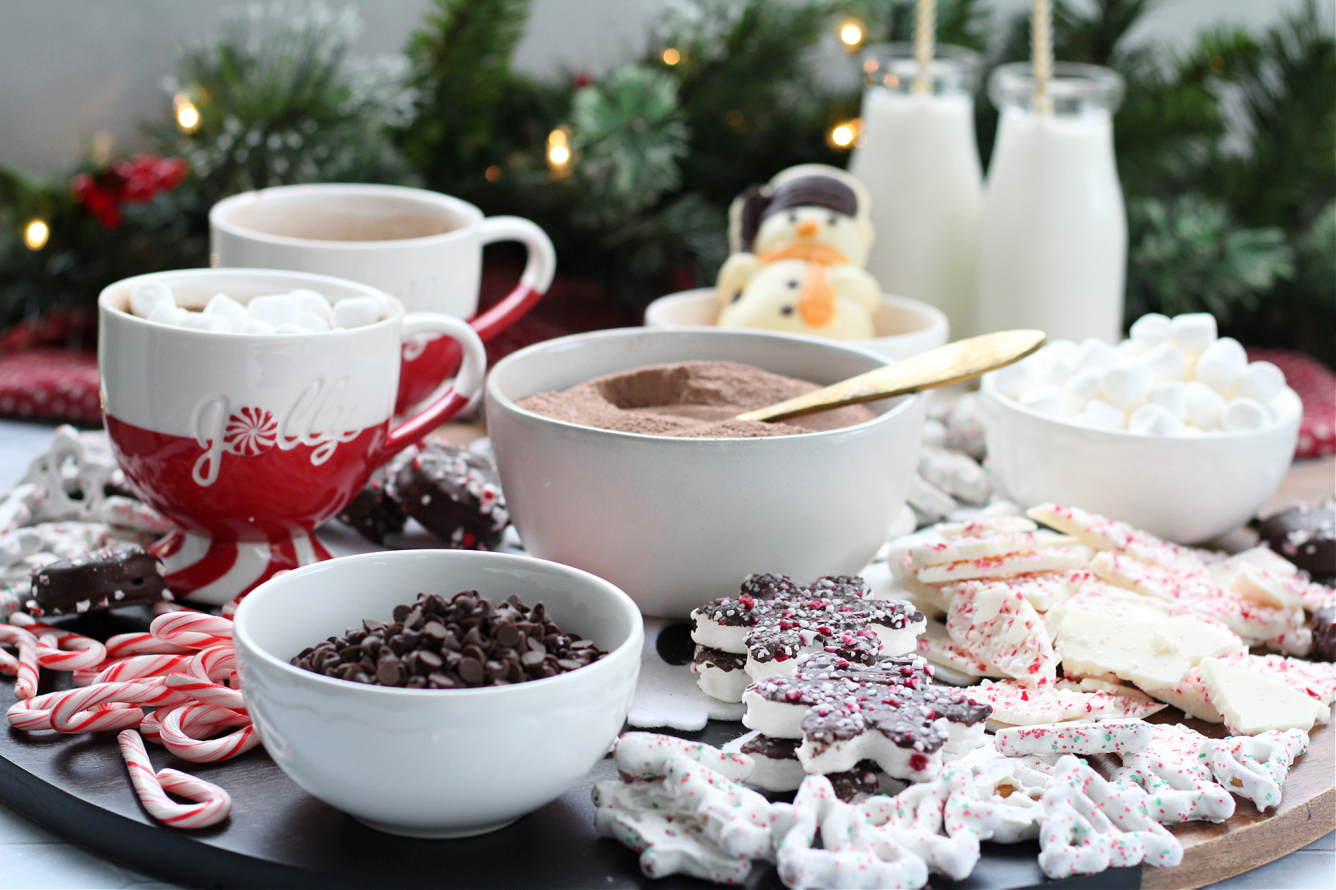 Peppermint hot cocoa board filled with mugs of cocoa, candy canes, and peppermint treats.