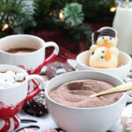 Close-up of a peppermint hot chocolate board featuring snowman cocoa toppers and candy.