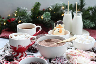 Holiday dessert board filled with hot cocoa ingredients and winter-themed treats.