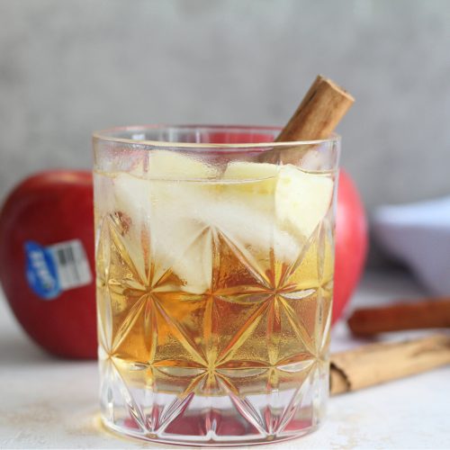 Close-up of glass of chilled apple sangria with JAZZ apples in the background.