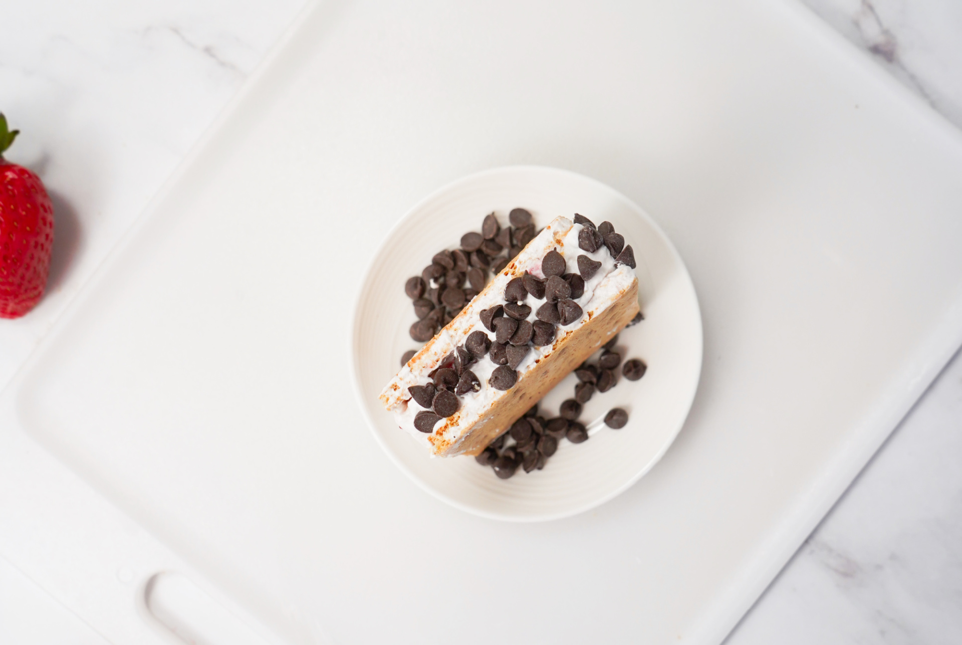 Dipping the edges of Cool Whip&ndash;filled graham cracker sandwiches into mini chocolate chips before freezing.