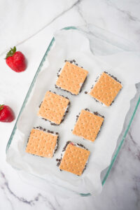 Cool whip ice cream sandwiches on parchment paper ready for the freezer.