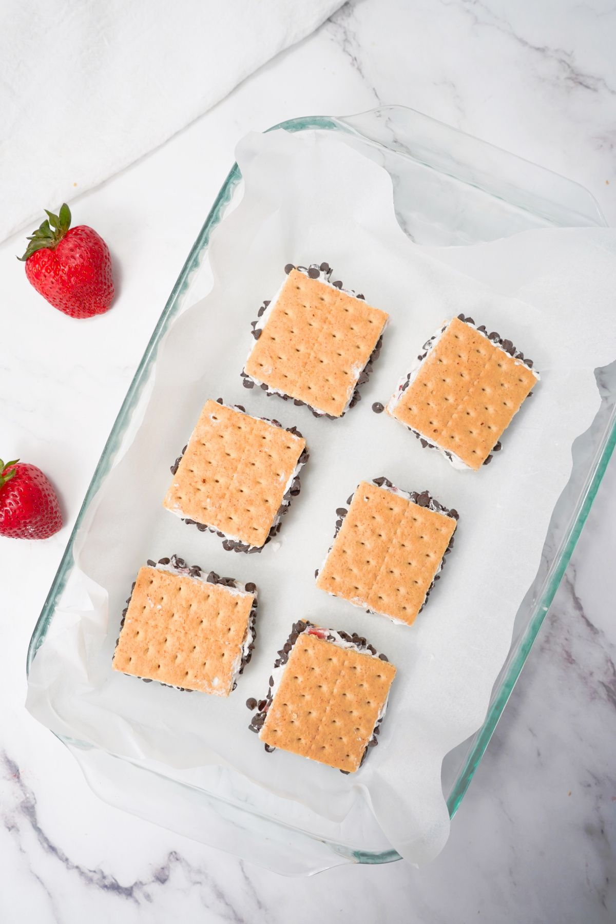 Cool whip ice cream sandwiches on parchment paper ready for the freezer.
