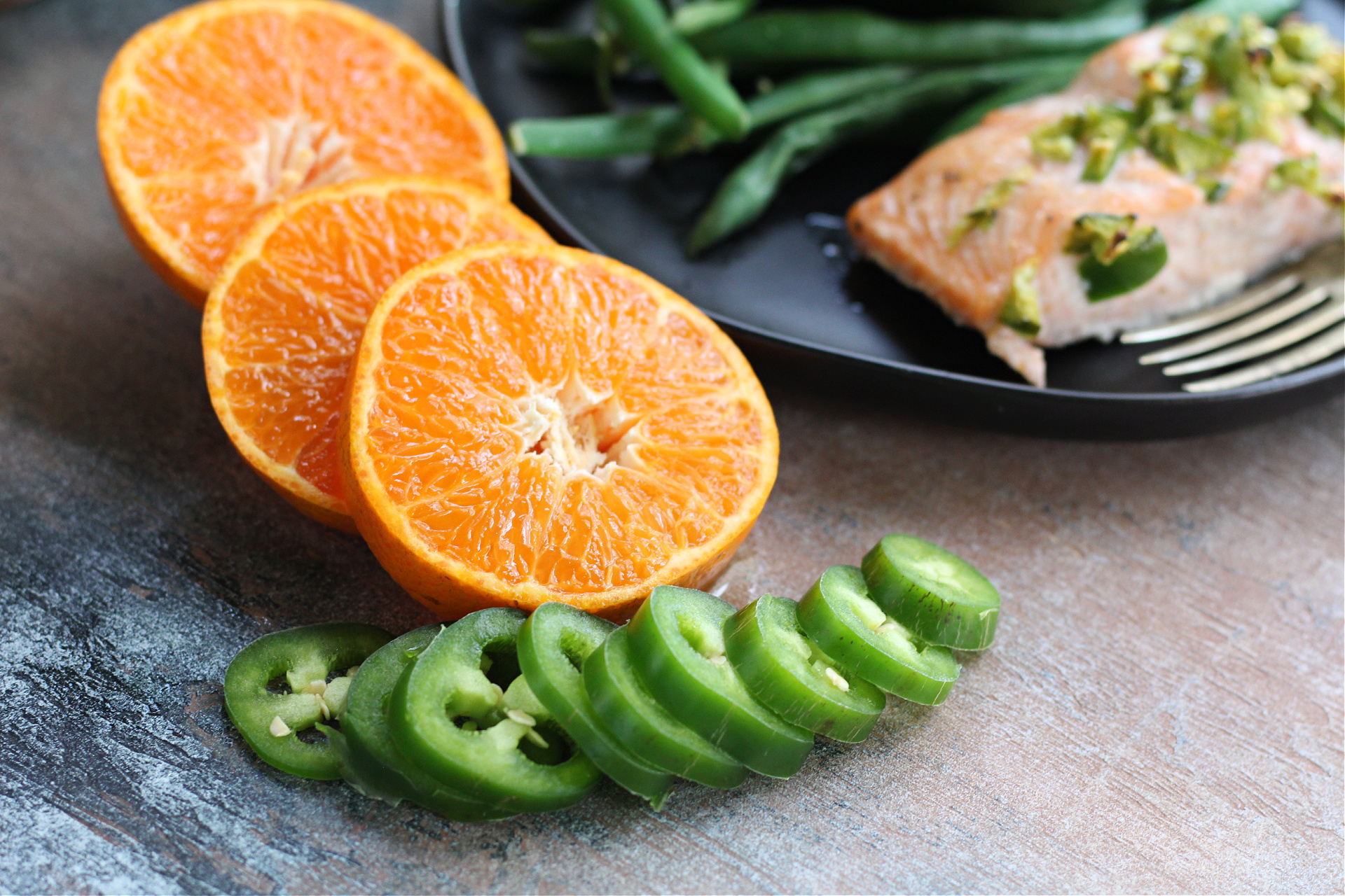 Healthy citrus glazed salmon fillet with fresh tangerines and herbs.