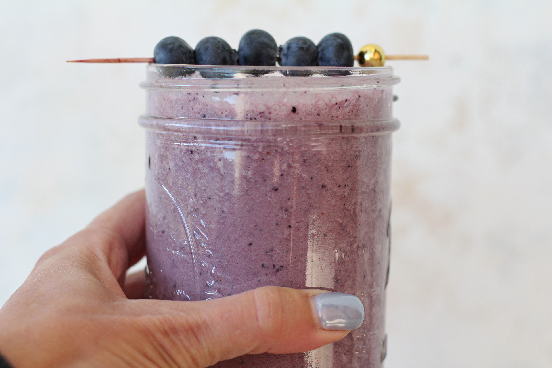Beet blueberry smoothie in a mason jar with fresh blueberries