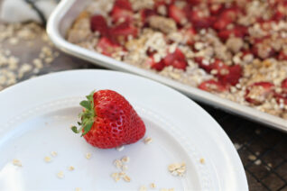 Close-up of juicy strawberry with oatmeal bars on a baking sheet in the background