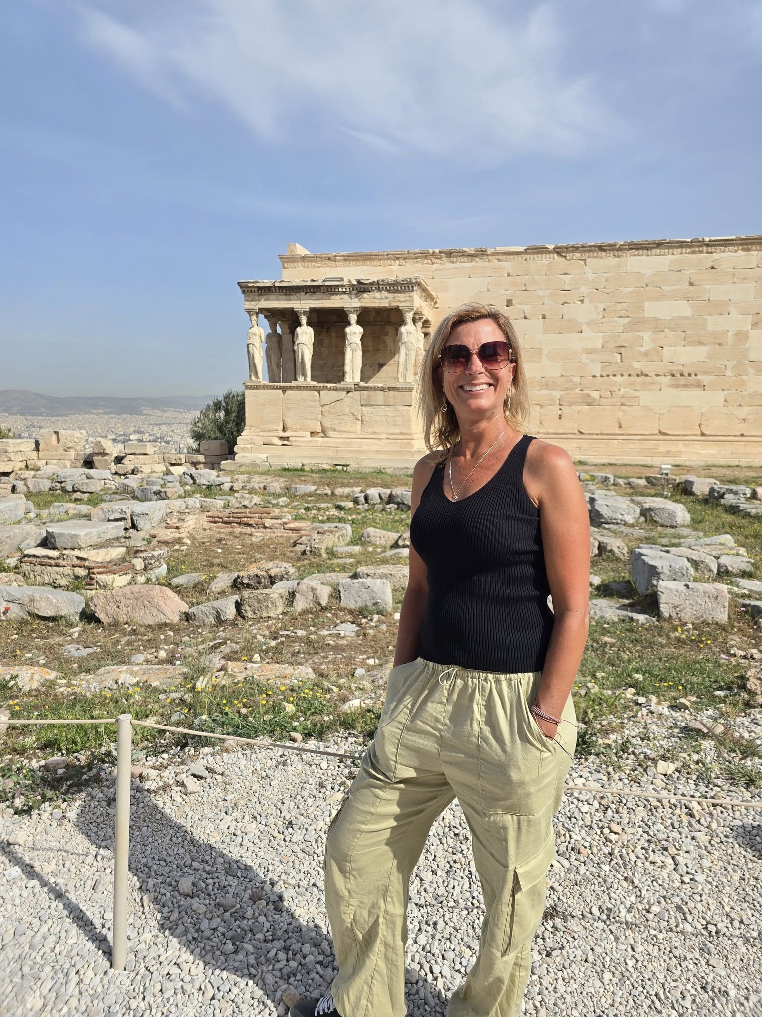 Woman visiting the Acropolis in Athens Greece with the Erechtheion and Caryatid statues in the background