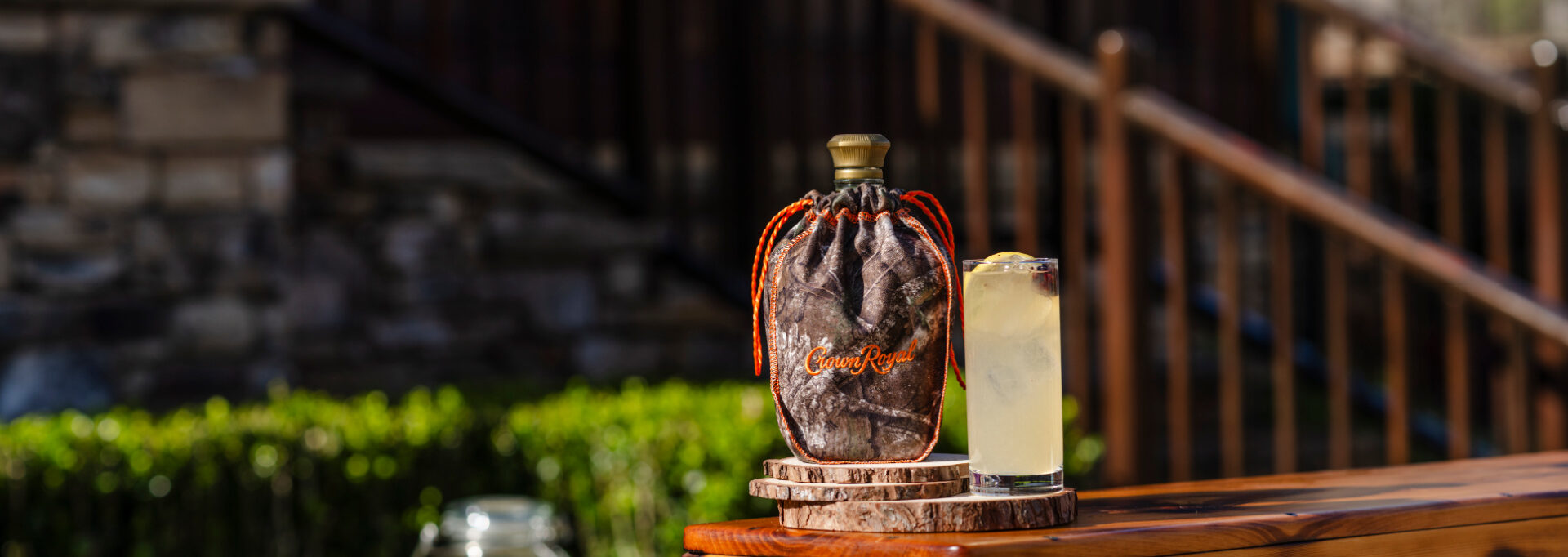 The Camo Crown Cooler cocktail served over ice with lemon garnish in a clear glass.