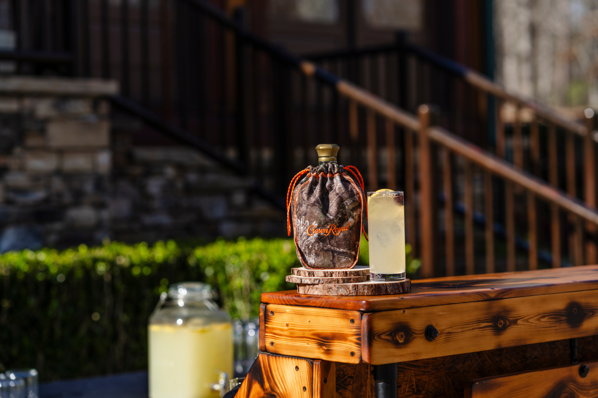 The Camo Crown Cooler cocktail served over ice with lemon garnish in a clear glass.