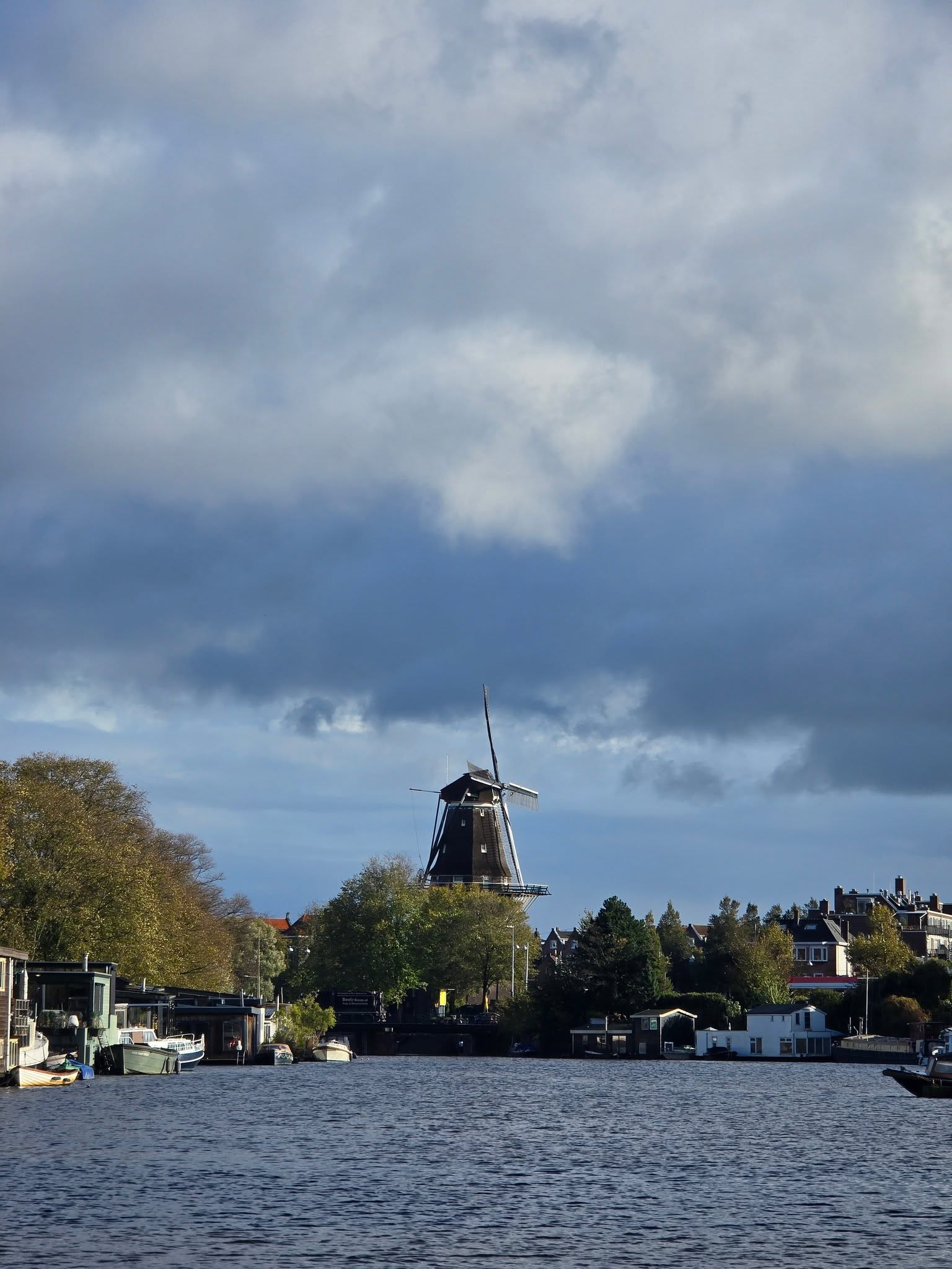 Amsterdam canal with a traditional windmill in the distance