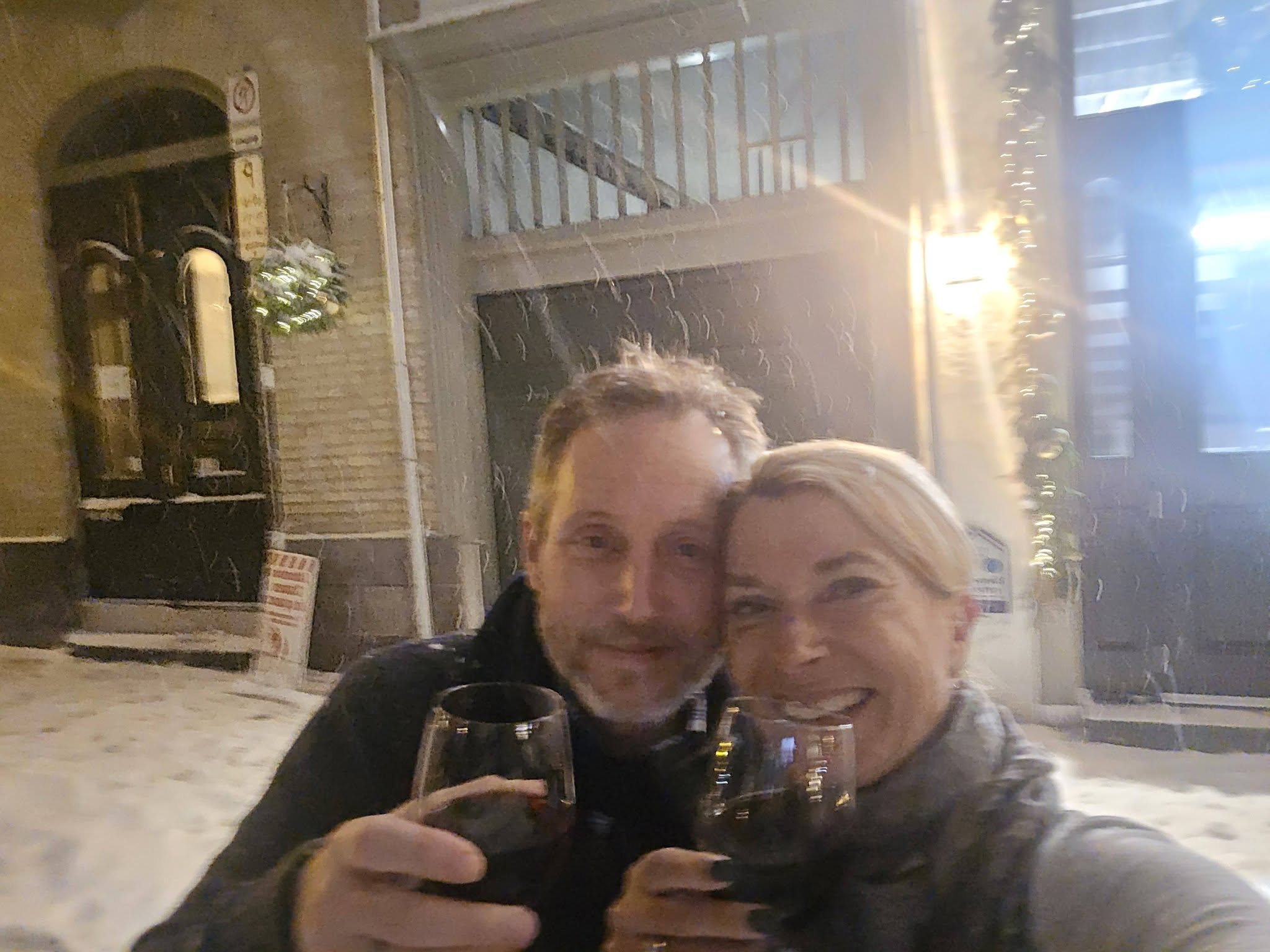 Couple on the snowy streets of Quebec City in front of Hotel Acadia