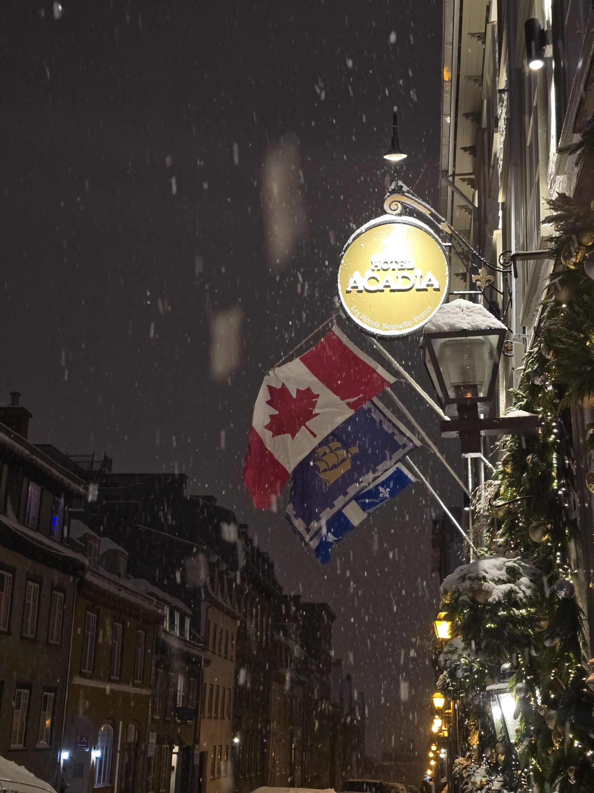 Hotel Acadia Sign on a snowy night with the Canadian flag in the background