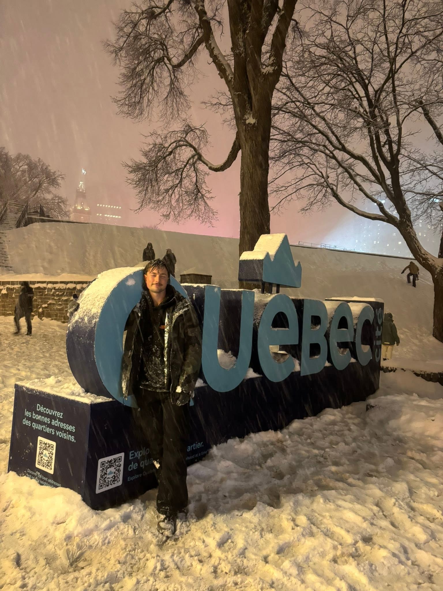 Man in front of Quebec sign in Canada