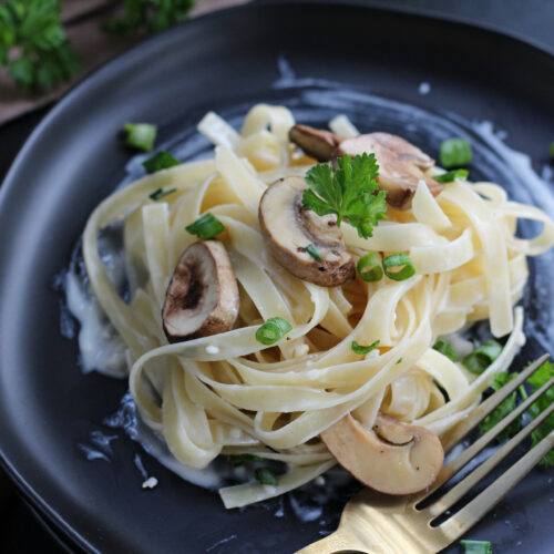 Easy homemade Alfredo sauce with sautéed mushrooms served over pasta
